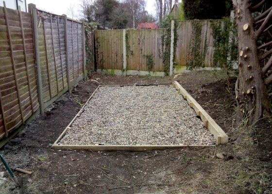 Compacted gravel base with retaining sleeper